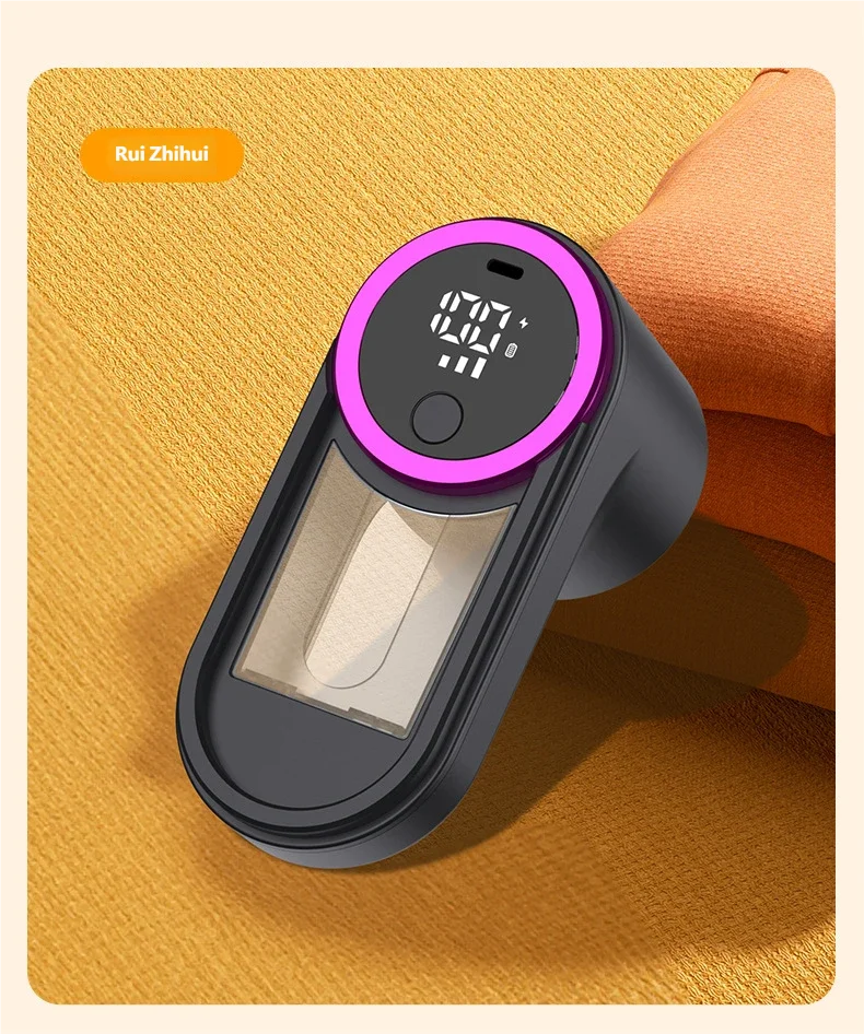 Gadget high-tech numérique avec écran LED et anneau violet, posé sur tissu texturé
