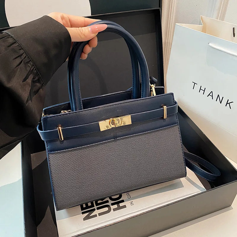 Sac à main bleu marine et gris avec fermoir doré, poignées courtes, idéal pour femme élégante