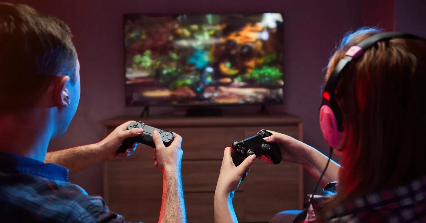 Deux joueurs avec manettes et casque gaming devant TV, ambiance lumineuse, expérience immersive