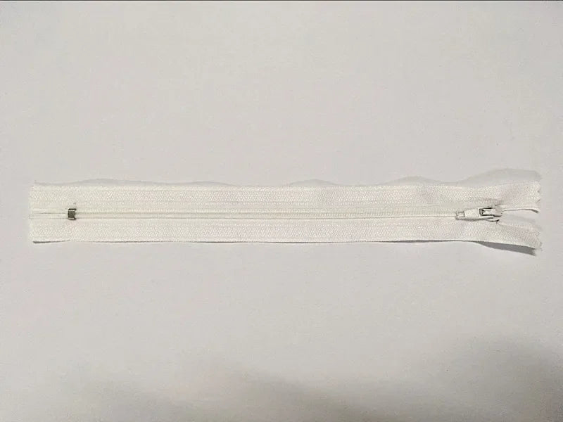Fermeture éclair blanche en tissu avec glissière métallique, idéale pour vêtements ou accessoires de couture